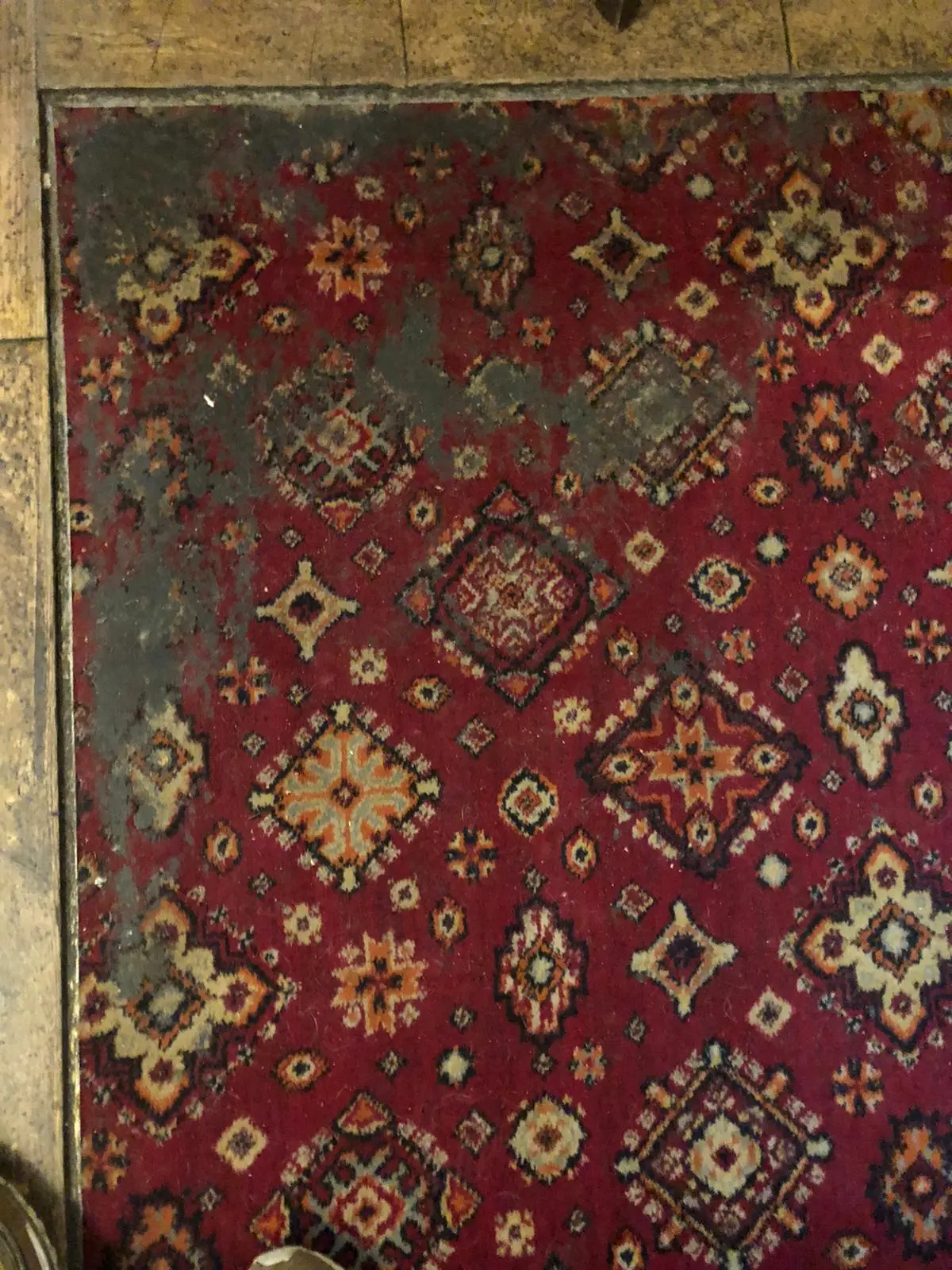 Traditional red patterned rug faded and dirty before restoration